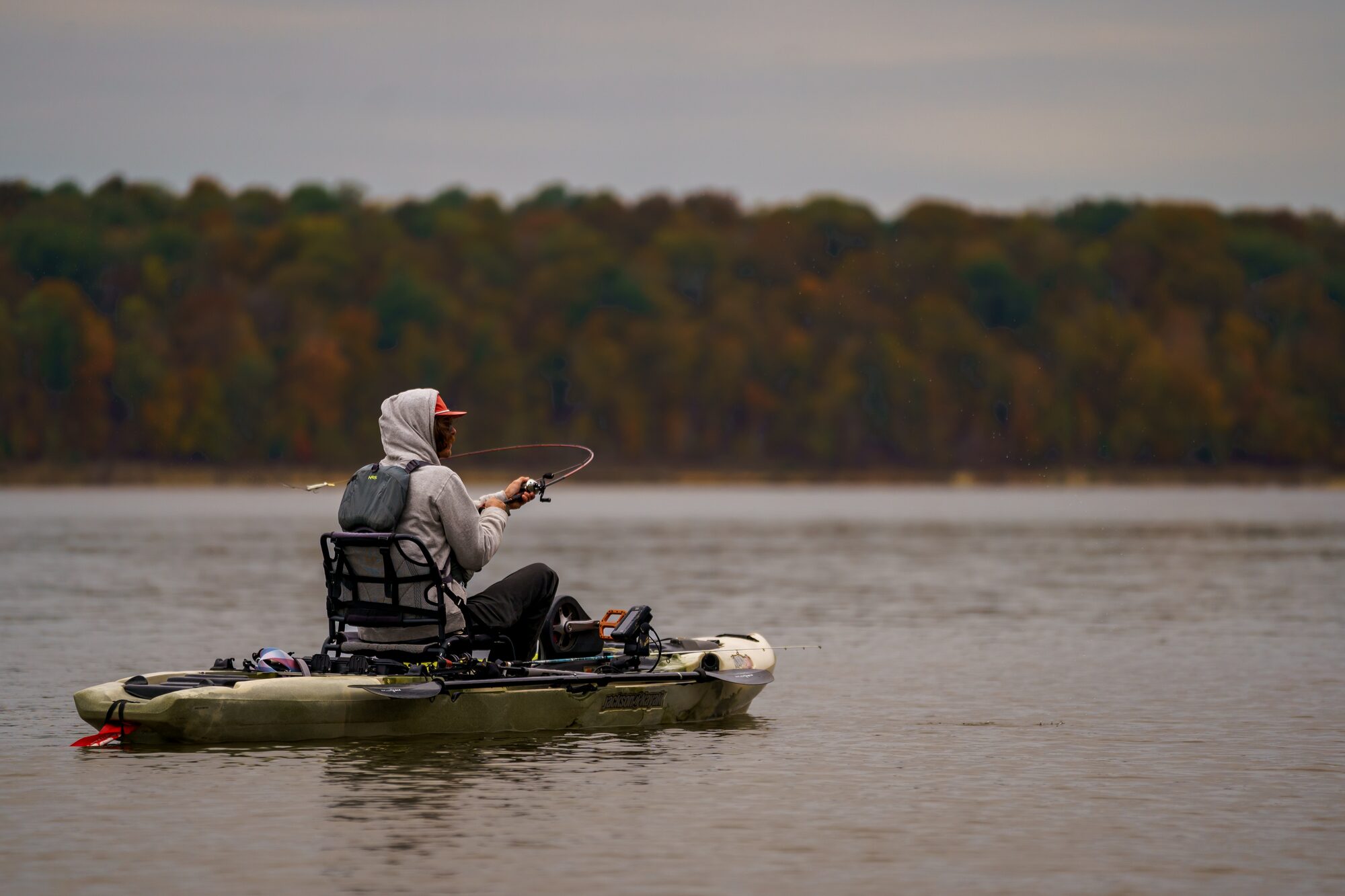 Angler fishing from a kayak on a calm regional fishery
